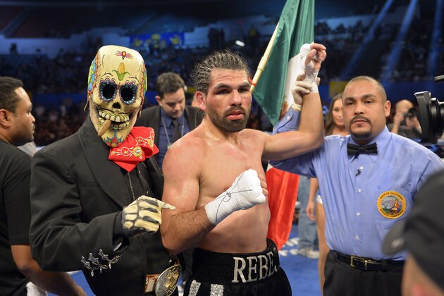 Alfredo Angulo, center, has his arm held up by the referee as a member of his team stands by after Angulo defeated Jorge Silva in their middleweight bout, Saturday, Dec. 15, 2012, in Los Angeles.  (AP Photo/Mark J. Terrill)