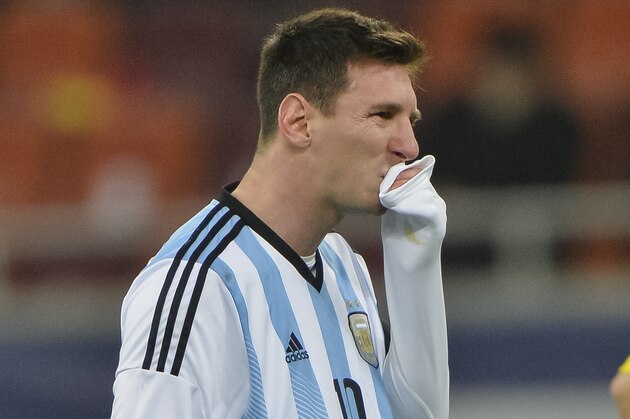 Argentina's Lionel Messi wipes his mouth after appearing to vomit on the pitch during an international friendly soccer game against Romania on the National Arena stadium in Bucharest, Romania, Wednesday, March 5, 2014. (AP Photo) ROMANIA OUT