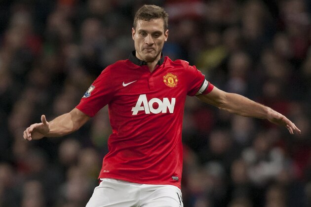 Manchester United's Nemanja Vidic takes the ball downfield during his team's English Premier League soccer match against Swansea City at Old Trafford Stadium, Manchester, England, Saturday Jan. 11, 2014. (AP Photo/Jon Super)