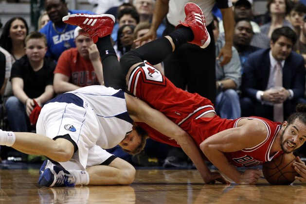 Chicago Bulls center Joakim Noah, right, tumbles over Dallas Mavericks forward Dirk Nowitzki (41), of Germany, to recover a loose ball during the second half of an NBA basketball game on Friday, Feb. 28, 2014, in Dallas. Chicago won 100-91. (AP Photo/John F. Rhodes)
