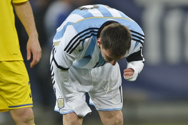 Argentina's Lionel Messi appears to vomit during an international friendly soccer game against Romania on the National Arena stadium in Bucharest, Romania, Wednesday, March 5, 2014. (AP Photo) ROMANIA OUT
