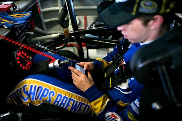 LAS VEGAS, NV - MARCH 09:  Brad Keselowski, driver of the #2 Miller Lite Dodge, uses his cellphone to tweet in the garage during practice for the NASCAR Sprint Cup Series Kobalt Tools 400 at Las Vegas Motor Speedway on March 9, 2012 in Las Vegas, Nevada.  (Photo by Tom Pennington/Getty Images)