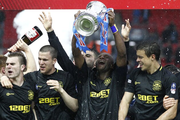 In this picture made available May 12 Wigan Athletic players including their captain Emmerson Boyce, centre, celebrate after their 1-0 win over Manchester City in their English FA Cup final soccer match at Wembley Stadium, London, Sunday, May 12, 2013. (AP Photo/Jon Super)