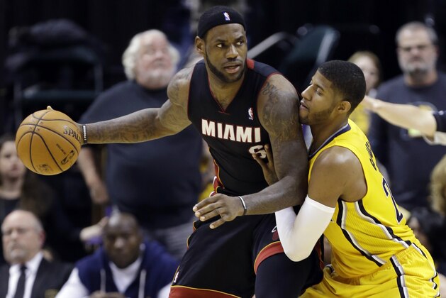 Miami Heat forward LeBron James, left, is defended by Indiana Pacers forward Paul George in the second half of an NBA basketball game in Indianapolis, Tuesday, Dec. 10, 2013. The Pacers won 90-84. (AP Photo/Michael Conroy)