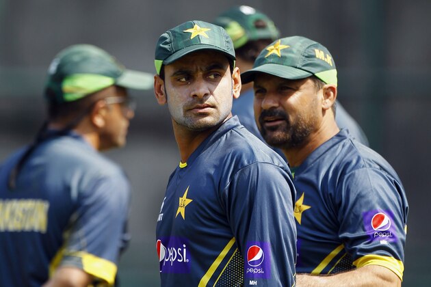 Pakistan’s Mohammad Hafeez, center, and coach Moin Khan, right, attend a team practice session in Dhaka, Bangladesh, Friday, March 7, 2014. Pakistan will face Sri Lanka in the Asia Cup final match on Saturday, March 8. (AP Photo/A.M. Ahad)