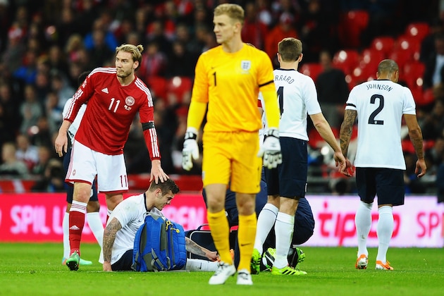 LONDON, ENGLAND - MARCH 05: Nicklas Bendtner of Denmark checks on Jack Wilshere of England as he receives treatment during the International Friendly match between England and Denmark at Wembley Stadium on March 5, 2014 in London, England.  (Photo by Laurence Griffiths/Getty Images)
