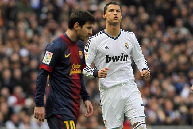 Real Madrid's Cristiano Ronaldo from Portugal, right, and FC Barcelona's Lionel Messi from Argentina, left, gesture during a Spanish La Liga soccer match at the Santiago Bernabeu stadium in Madrid, Spain, Saturday, March 2, 2013. (AP Photo/Andres Kudacki)