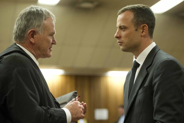 Oscar Pistorius, right, talks with his attorney, Barry Roux in court on the fifth day of his trial at the high court in Pretoria, South Africa, Friday, March 7, 2014.  Pistorius is charged with murder for the shooting death of his girlfriend,  Reeva Steenkamp, on Valentines Day in 2013.  (AP Photo/Theana Breugem, Pool)