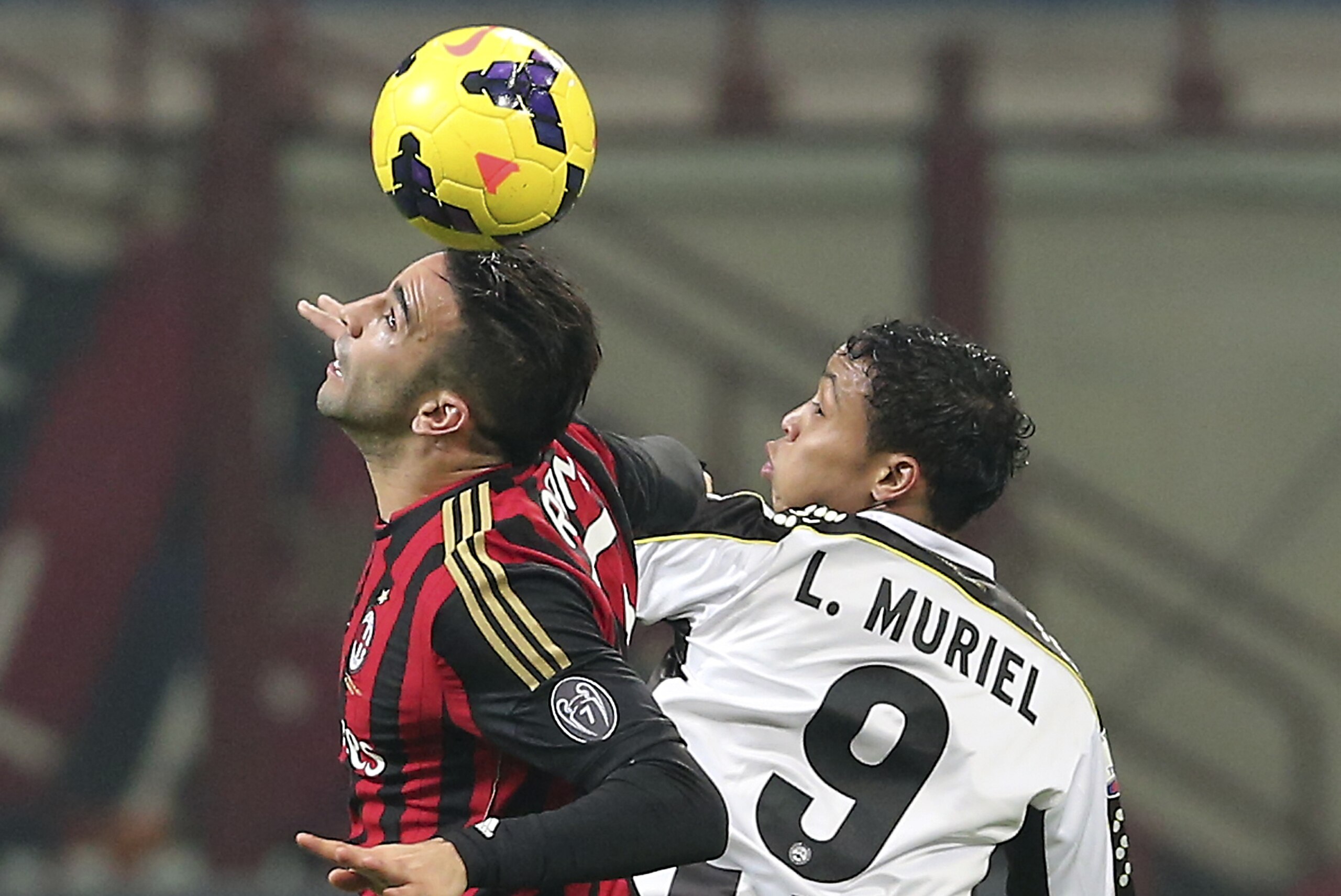 AC Milan defender Adil Rami, left, of France, challenges for the ball with Udinese forward Luis Muriel, of Colombia, during their Italian Cup soccer match, at the San Siro stadium in Milan, Italy, Wednesday, Jan. 22, 2014. (AP Photo/Antonio Calanni)