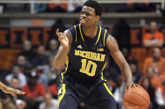 Michigan guard Derrick Walton Jr. (10) directs traffic in the second half of an NCAA college basketball game against Illinois on Tuesday, March 4, 2014, in Champaign, Ill. Michigan won 84-53. (AP Photo/Rick Danzl)