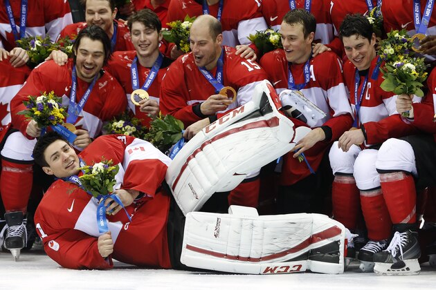 Canada goalie Carey Price, front, lies on the ice as he poses with teammates after Canada beat Sweden 3-0 in the men's ice hockey gold medal game at the 2014 Winter Olympics, Sunday, Feb. 23, 2014, in Sochi, Russia. (AP Photo/Mark Humphrey)