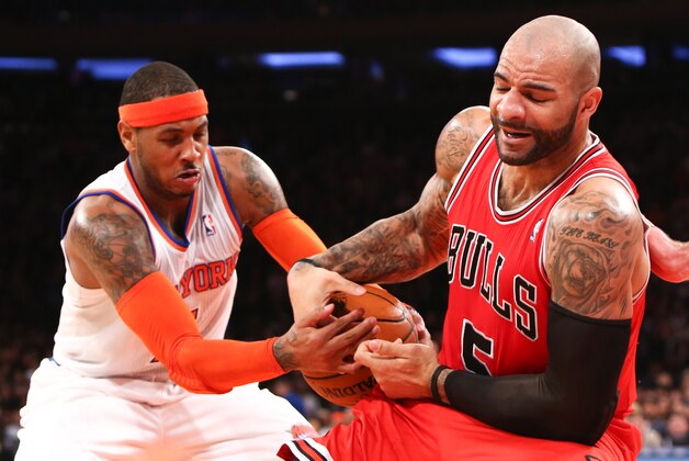 Dec. 21, 2012; New York, NY, USA; New York Knicks small forward Carmelo Anthony (7) and Chicago Bulls power forward Carlos Boozer (5) battle for the ball during the first half at Madison Square Garden. Mandatory Credit: Debby Wong-USA TODAY Sports