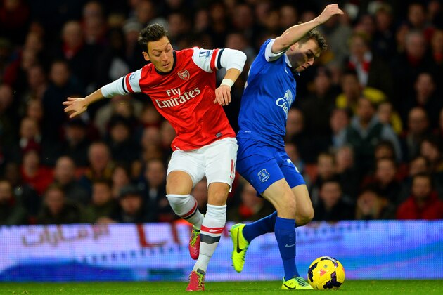 LONDON, ENGLAND - DECEMBER 08:  Mesut Oezil of Arsenal and Seamus Coleman of Everton battle for the ball during the Barclays Premier League match between Arsenal and Everton at Emirates Stadium on December 8, 2013 in London, England.  (Photo by Michael Regan/Getty Images)