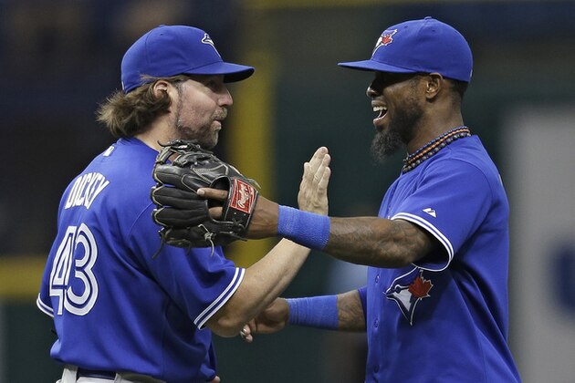 Toronto Blue Jays starting pitcher R.A. Dickey, left, celebrates with shortstop Jose Reyes after the team shut out the Tampa Bay Rays 3-0 in a baseball game Wednesday, June 26, 2013, in St. Petersburg, Fla. Dickey pitched a complete game. (AP Photo/Chris O'Meara)