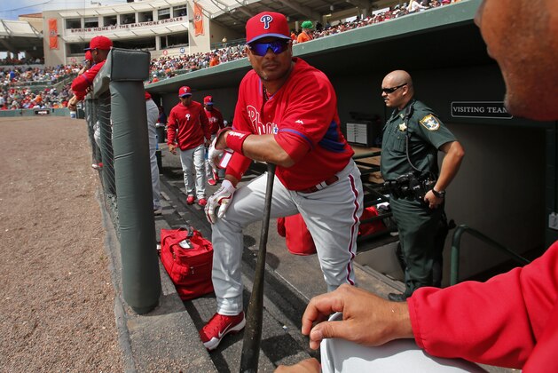 Philadelphia Phillies' Bobby Abreu, center, stands on the dugout steps during an exhibition spring training baseball game against the Baltimore Orioles in Sarasota, Fla., Friday, March 7, 2014. (AP Photo/Gene J. Puskar)