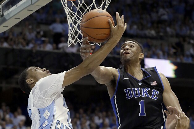 Duke's Jabari Parker (1) blocks North Carolina's Nate Britt during the first half of an NCAA college basketball game in Chapel Hill, N.C., Thursday, Feb. 20, 2014. (AP Photo/Gerry Broome)