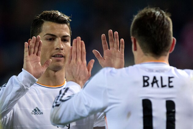 MADRID, SPAIN - FEBRUARY 11: Cristiano Ronaldo (L) of Real Madrid CF clashes hands with his teammate Gareth Bale (R) after a penalty over Bale during the Copa del Rey semi-final second leg match between Club Atletico de Madrid and Real Madrid CF at Vicente Calderon Stadium on February 11, 2014 in Madrid, Spain.  (Photo by Gonzalo Arroyo Moreno/Getty Images)