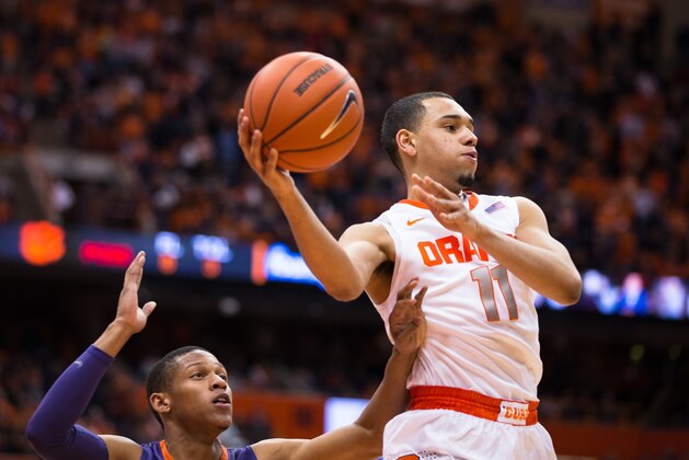 SYRACUSE, NY - FEBRUARY 9:  Tyler Ennis #11 of the Syracuse Orange makes a jumping pass while being defended by Jaron Blossomgame #5 of the Clemson Tigers during the second half on February 9, 2014 at The Carrier Dome in Syracuse, New York.  Syracuse defeats Clemson 57-44. (Photo by Brett Carlsen/Getty Images)