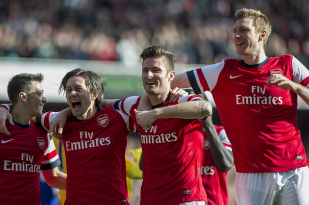 Arsenal's Olivier Giroud, second right, celebrates with teammates Mesut Ozil left, Tomas Rosicky, second left, and Per Mertesacker , right, after scoring against Everton, during their FA Cup quarterfinal soccer match, at Emirates Stadium, in London, Saturday, March 8, 2014. (AP Photo/Bogdan Maran)