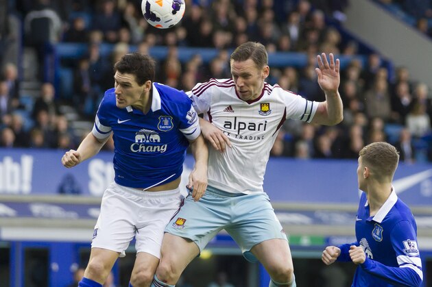 Everton's Gareth Barry, left, fights for the ball against West Ham United's Kevin Nolan during their English Premier League soccer match at Goodison Park Stadium, Liverpool, England, Saturday March 1, 2014. (AP Photo/Jon Super)