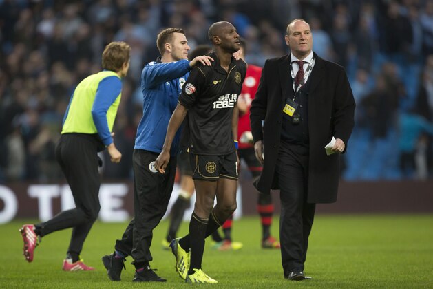 Wigan's Emmerson Boyce, centre, is congratulated by teammate Callum McManaman, centre left, after their 2-1 win against Manchester City following their English FA Cup quarterfinal soccer match at the Etihad Stadium, Manchester, England, Sunday, March 9, 2014. (AP Photo/Jon Super)