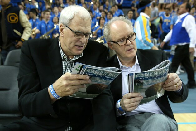 LOS ANGELES, CA - JANUARY 09:  NBA coaching legend Phil Jackson (L) and actor John Lithgow consult their programs before the game between the Arizona Wildcats and the UCLA Bruins at Pauley Pavilion on January 9, 2014 in Los Angeles, California.  (Photo by Stephen Dunn/Getty Images)