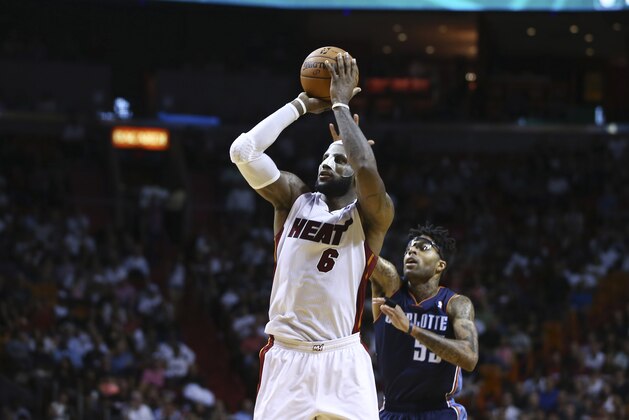 Charlotte Bobcats' Chris Douglas-Robert (55) tries to block Miami Heat's LeBron James (6) during the second half of an NBA basketball game in Miami, Monday, March 3, 2014. LeBron James scored a team record of 61 points. The Heat won 124-107. (AP Photo/J Pat Carter)