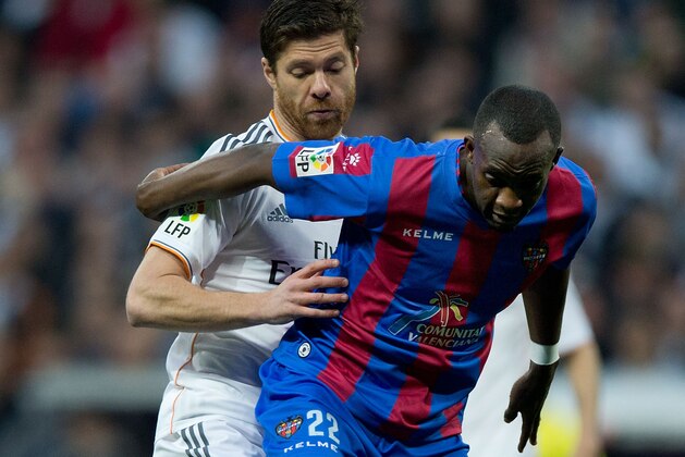 MADRID, SPAIN - MARCH 09: Xabi Alonso of Real Madrid CF competes for the ball behind Mohamed Sissoko of Levante UD during the La Liga match between Real Madrid CF and Levante UD at Estadio Satiago Bernabeu on March 9, 2014 in Madrid, Spain.  (Photo by Gonzalo Arroyo Moreno/Getty Images)