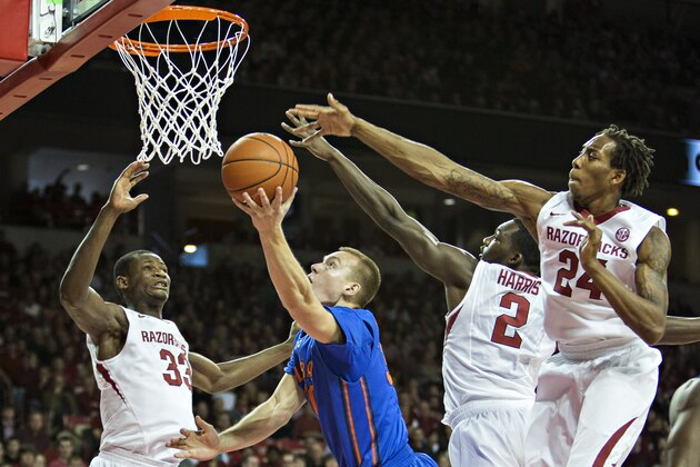 FAYETTEVILLE, AR - JANUARY 11:  Jacob Kurtz #30 of the Florida Gators goes up for a lay up past Michael Qualls #24 and Alandise Harris #2 of the Arkansas Razorbacks at Bud Walton Arena on January 11, 2014 in Fayetteville, Arkansas.  (Photo by Wesley Hitt/Getty Images)