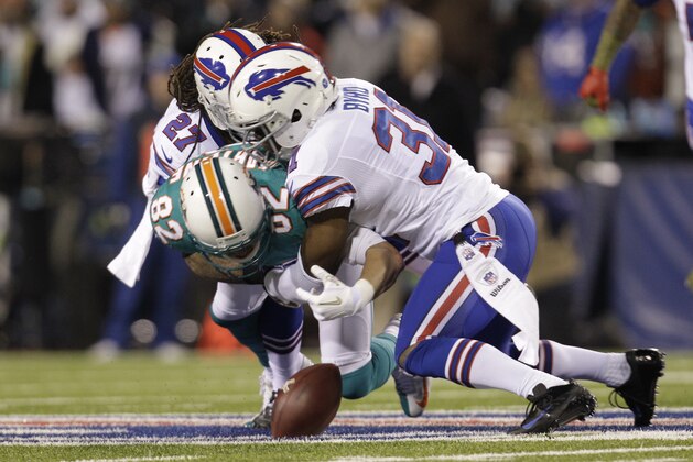 Miami Dolphins Brian Hartline (82) fumbles the ball asBuffalo Bills' Stephon Gilmore (27) and Jairus Byrd (31) hit him during the first half of an NFL football game Thursday, Nov. 15, 2012 in Orchard Park, N.Y.  Byrd recovered the fumble on the play.(AP Photo/Gary Wiepert)