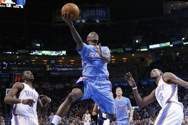 Los Angeles Clippers guard Jamal Crawford (11) goes up for a shot between Oklahoma City Thunder defenders Reggie Jackson (15) and Kevin Durant (35) in the second quarter of an NBA basketball game, Sunday, Feb. 23, 2014, in Oklahoma City. (AP Photo/Sue Ogrocki)