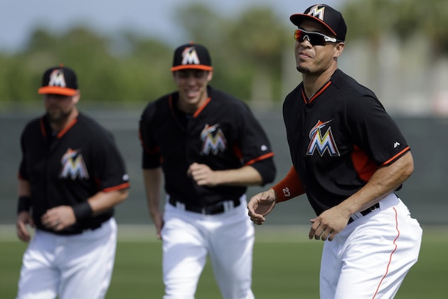 Miami Marlins' Giancarlo Stanton, right, Christian Yelich, center, and Casey McGehee warm up during spring training baseball practice Thursday, Feb. 20, 2014, in Jupiter, Fla. (AP Photo/Jeff Roberson)