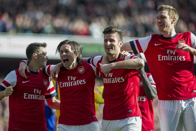 Arsenal's Olivier Giroud, second right, celebrates with teammates Mesut Ozil left, Tomas Rosicky, second left, and Per Mertesacker , right, after scoring against Everton, during their FA Cup quarterfinal soccer match, at Emirates Stadium, in London, Saturday, March 8, 2014. (AP Photo/Bogdan Maran)