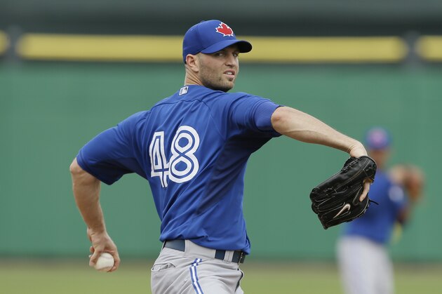 Toronto Blue Jays starting pitcher J.A. Happ warms up before an exhibition baseball game against the Philadelphia Phillies Wednesday, Feb. 26, 2014, in Clearwater, Fla. (AP Photo/Charlie Neibergall)