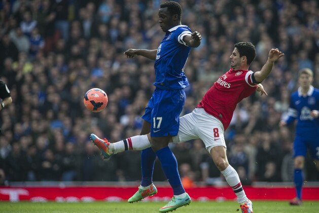 Arsenal's Mikel Arteta, fights for the ball with Everton's Romelu Lukaku, during their FA Cup quarterfinal soccer match, at Emirates Stadium, in London, Saturday, March 8, 2014. (AP Photo/Bogdan Maran)