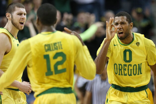 Oregon's Ben Carter, left, and Mike Moser, right, celebrate with teammate Jason Calliste, center, after Calliste hit a 3-point shot late in the game against Arizona in an NCAA college basketball game in Eugene, Ore. on Saturday, March 8, 2014. (AP Photo/Chris Pietsch)