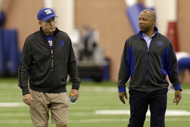 New York Giants head coach Tom Coughlin, left, and general manager Jerry Reese walk off the field after a minicamp in East Rutherford, N.J., Thursday, June 13, 2013.   (AP Photo/Seth Wenig)