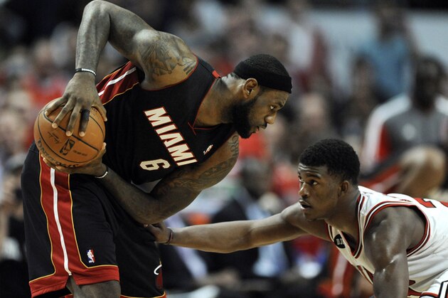Miami Heat's LeBron James (6) looks to drive around Chicago Bulls' Jimmy Butler  during overtime of an NBA basketball game in Chicago, Sunday, March 9, 2014. The Bulls won 95-88. (AP Photo/ Paul Beaty)