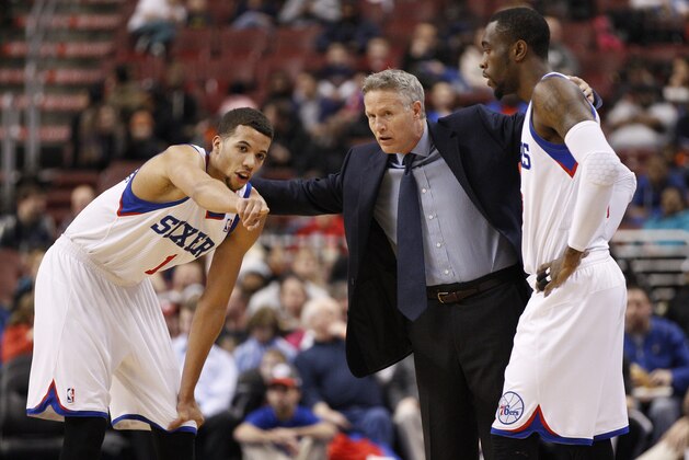 Philadelphia 76ers' Michael Carter-Williams, left, points things out to head coach Brett Brown, center, and Tony Wroten , right, during the first half of an NBA basketball game against the Milwaukee Bucks, Monday, Feb. 24, 2014, in Philadelphia. The Bucks won 130-110. (AP Photo/Chris Szagola)