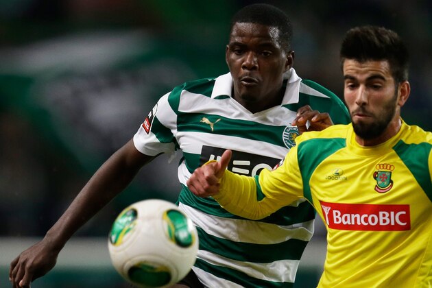 Sporting's William Carvalho, left, fights for the ball with Pacos de Ferreira's Sergio Oliveira  during their Portuguese league soccer match Sunday, Dec. 1, 2013, at Sporting's Alvalade stadium in Lisbon. (AP Photo/Armando Franca)