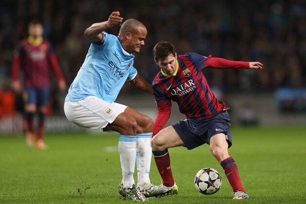 MANCHESTER, ENGLAND - FEBRUARY 18:  Lionel Messi of Barcelona competes with Vincent Kompany of Manchester City during the UEFA Champions League Round of 16 first leg match between Manchester City and Barcelona at the Etihad Stadium on February 18, 2014 in Manchester, England.  (Photo by Clive Brunskill/Getty Images)