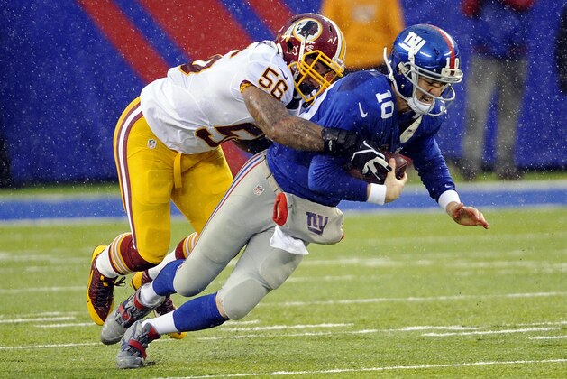 New York Giants quarterback Eli Manning (10) is sacked by Washington Redskins' Perry Riley (56) during the first half of an NFL football game Sunday, Dec. 29, 2013, in East Rutherford, N.J.  (AP Photo/Bill Kostroun)