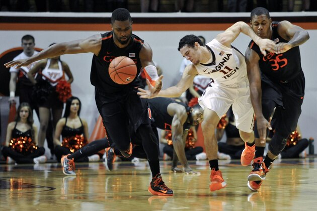 Feb 15, 2014; Blacksburg, VA, USA; Virginia Tech Hokies guard Devin Wilson (11) is fouled by Miami Hurricanes forward James Kelly (35) and forward Raphael Akpejiori in the second half at Cassell Coliseum. Mandatory Credit: Michael Shroyer-USA TODAY Sports
