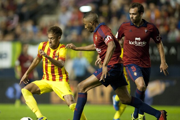 FC Barcelona's Neymar , of Brazil, left, duels for the ball with  Osasuna's Jordan Loties of France, center, and Lolo, during their Spanish League soccer match, at El Sadar stadium, in Pamplona northern Spain on Saturday, Oct. 19, 2013. (AP Photo/Alvaro Barrientos)