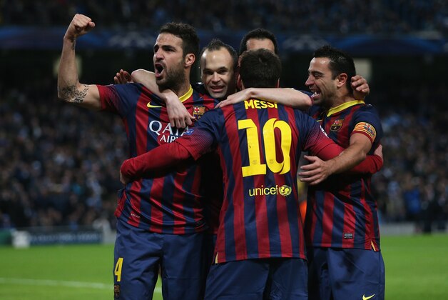 MANCHESTER, ENGLAND - FEBRUARY 18:  Lionel Messi of Barcelona celebrates scoring the opening goal from a penalty kick with his team-mates during the UEFA Champions League Round of 16 first leg match between Manchester City and Barcelona at the Etihad Stadium on February 18, 2014 in Manchester, England.  (Photo by Clive Brunskill/Getty Images)