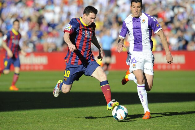 Barcelona's Lionel Messi from Argentina, left, and Valladolid's defender Jesus Rueda challenge for the ball during a Spanish La Liga soccer match at the Jose Zorrilla stadium in Valladolid, Spain, Saturday March 8, 2014. (AP Photo/Israel L. Murillo)