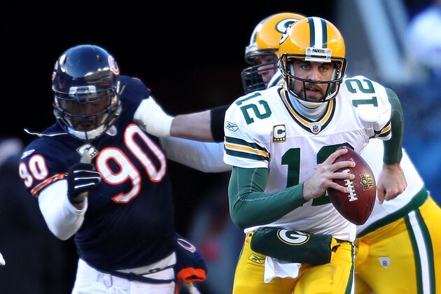 CHICAGO, IL - JANUARY 23:  Quarterback Aaron Rodgers #12 of the Green Bay Packers runs the ball ahead of Julius Peppers #90 of the Chicago Bears in the NFC Championship Game at Soldier Field on January 23, 2011 in Chicago, Illinois.  (Photo by Andy Lyons/Getty Images)