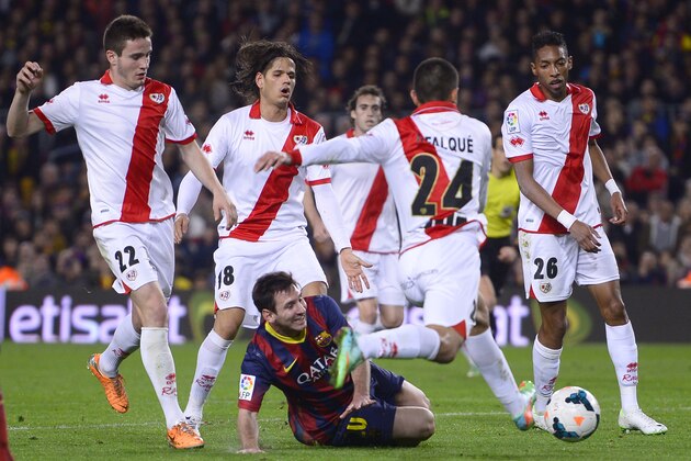 FC Barcelona's Lionel Messi, from Argentina, third left, duels for the ball against Rayo Vallecano's Iago Falque during a Spanish La Liga soccer match at the Camp Nou stadium in Barcelona, Spain, Saturday, Feb. 15, 2014. (AP Photo/Manu Fernandez)