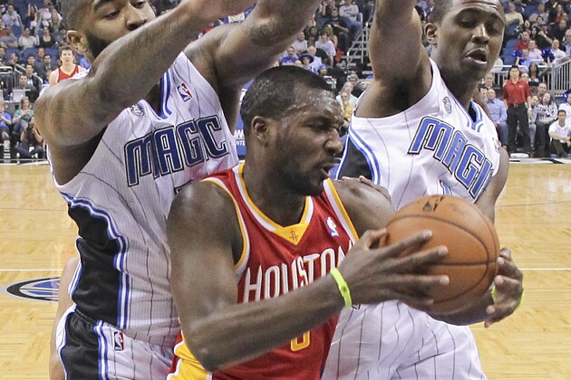 Houston Rockets' Jordan Hamilton (5) grabs a rebound in front of Orlando Magic's Kyle O'Quinn, left, and Doron Lamb during the first half of an NBA basketball game in Orlando, Fla., Wednesday, March 5, 2014. (AP Photo/John Raoux)