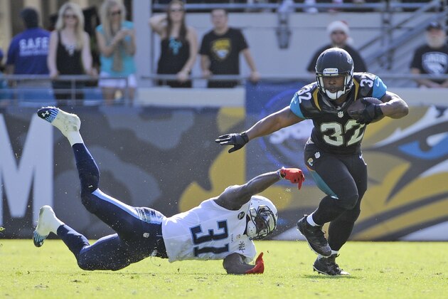 Jacksonville Jaguars running back Maurice Jones-Drew (32) makes a move to get around Tennessee Titans strong safety Bernard Pollard (31) during the first half of an NFL football game in Jacksonville, Fla., Sunday, Dec. 22, 2013.(AP Photo/Stephen Morton)